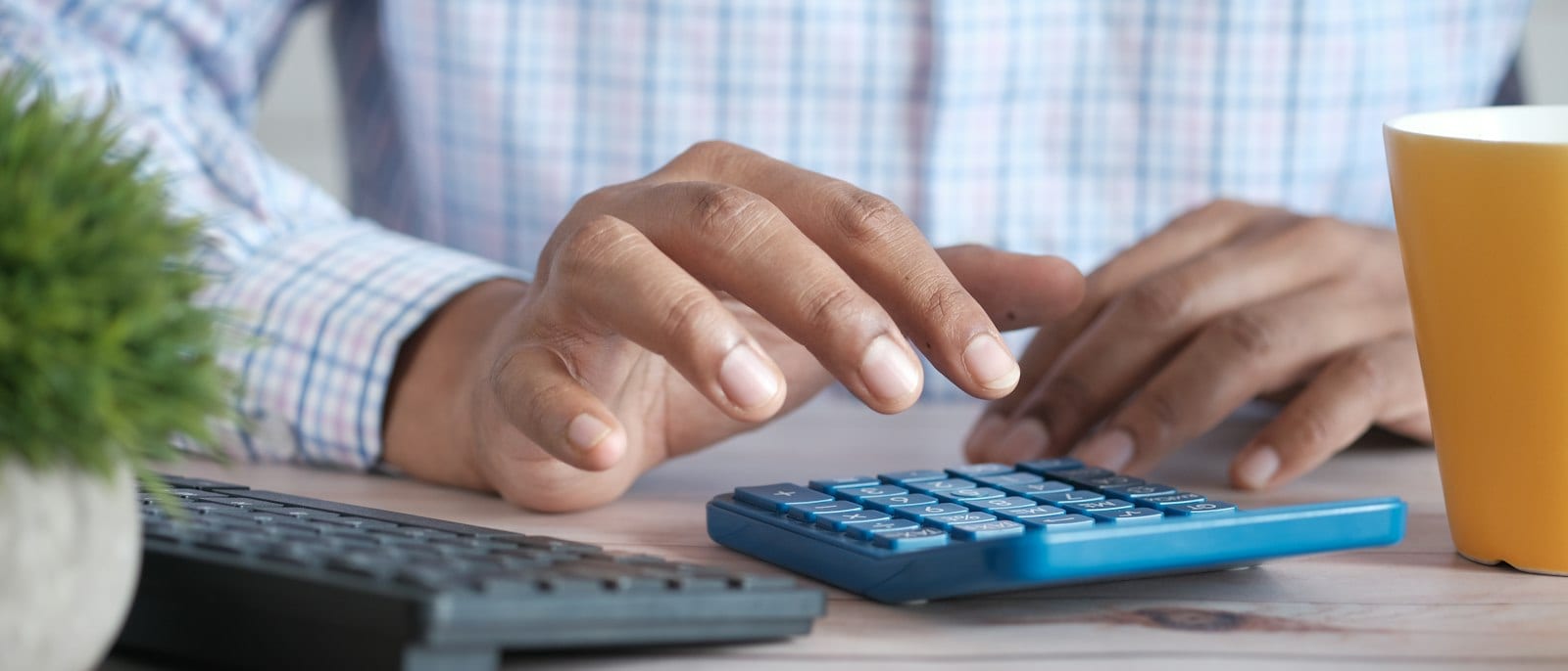 Person using a calculator next to plan documents